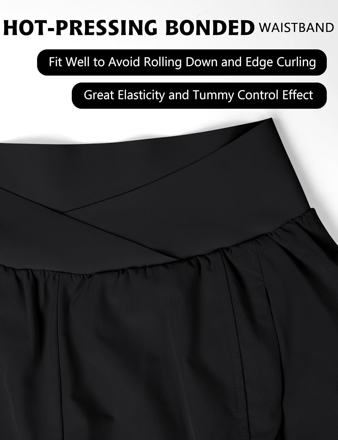 Black crossover high-waisted running shorts with zippered pockets and four-way stretch fabric — detail